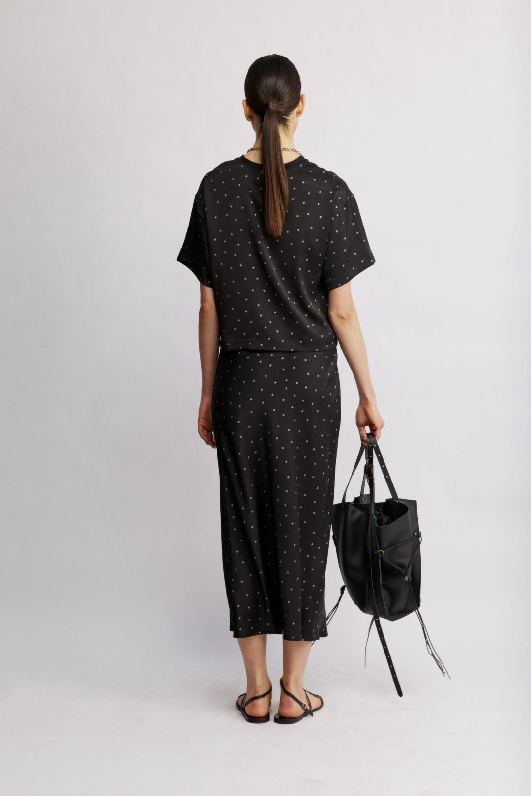 Eden חצאית מידי שחורה מנוקדת בגזרה ישרה מבד סאטן מייקרופייבר איכותי משכית