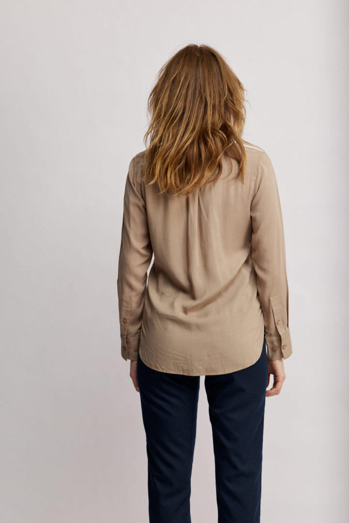 Janice מכופתרת בז' בגזרה קלאסית בעלת עיטורי רקמה עדינים בחזית. משכית