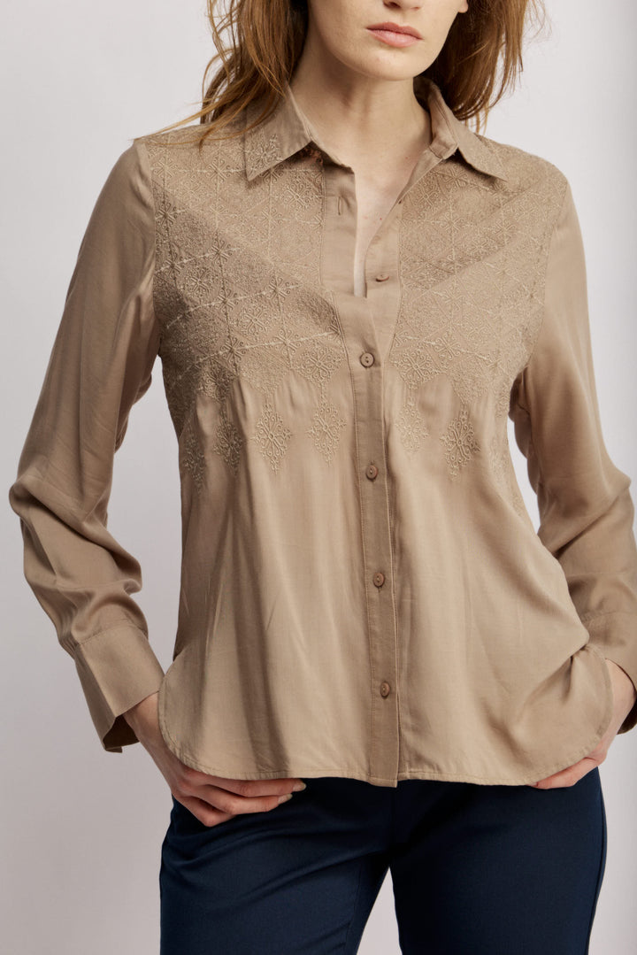 Janice מכופתרת בז' בגזרה קלאסית בעלת עיטורי רקמה עדינים בחזית. משכית